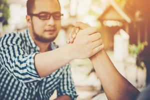 Close-up of two business people shaking hands while sitting at the working place photo