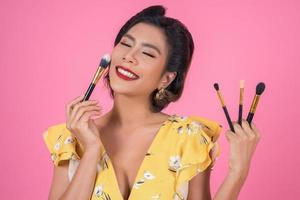 Portrait of a woman with makeup brushes photo