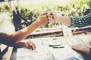 Close-up of two business people shaking hands while sitting at the working place photo