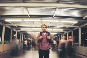 Handsome bearded man with backpack standing on the street traveling at night photo