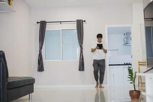 Asian man holding a tablet at home photo