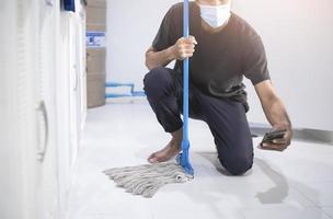 Asian man cleaning with a mop photo