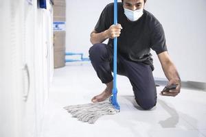 Asian man mopping the floor