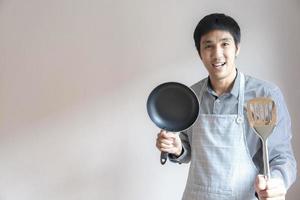 Man holding a pan and spatula photo