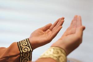 Manos de una mujer musulmana o islámica gesticulando mientras reza en casa