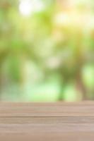 Empty wooden table with green blur light background photo