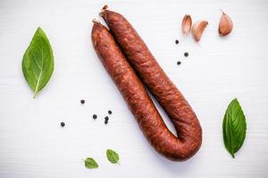 Chorizo sarta smoked sausage with basil leaves photo