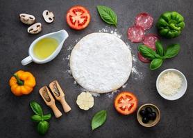 Fresh pizza dough and toppings photo