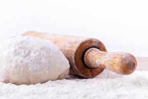 Dough and a rolling pin with flour photo