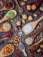 Vertical view of legumes and nuts in spoons photo