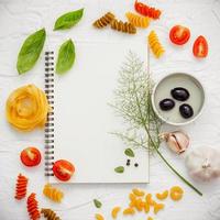 Top view of a notebook with Italian ingredients photo