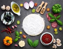 Pizza ingredients on dark stone photo