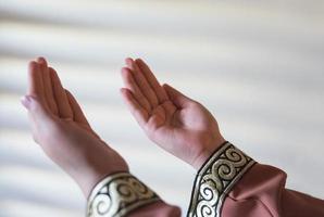 Hands of a Muslim or Islamic woman gesturing while praying at home photo