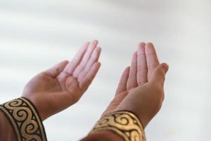 Hands of a Muslim or Islamic woman gesturing while praying at home photo