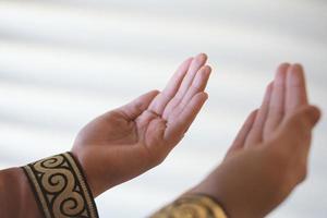 Hands of a Muslim or Islamic woman gesturing while praying at home photo