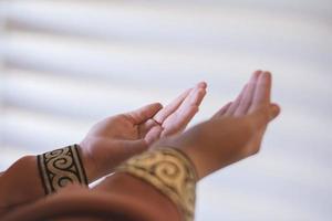 Manos de una mujer musulmana o islámica gesticulando mientras reza en casa foto