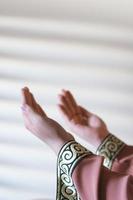 Manos de una mujer musulmana o islámica gesticulando mientras reza en casa foto