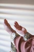 Hands of a Muslim or Islamic woman gesturing while praying at home photo
