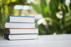 Close up pile of books, shot outdoors under clear natural bokeh background photo