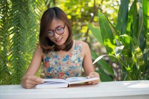 Young hipster woman reading books in home garden with nature photo