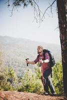 hombre viajero con mochila mirando el mapa mientras montañismo