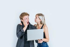 Portrait of happy young couple using laptop computer in studio photo