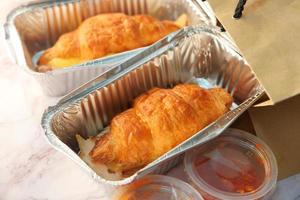 Croissants in take away containers, close up photo