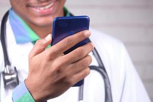 Doctor in a white coat using a smartphone photo