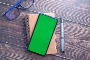 Top view of smart phone and notepad on table photo