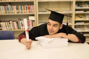 Happy graduate student holding a diploma in hand photo