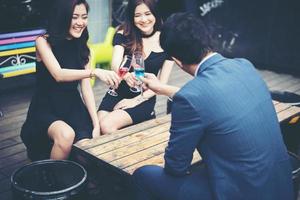 Portrait of happy young friends having fun and drinking together photo