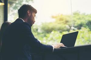 Young businessman working on laptop at office photo