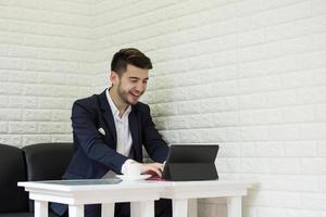Successful young businessman working on laptop at office