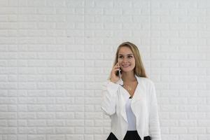 Young business lady using smartphone while working at office photo