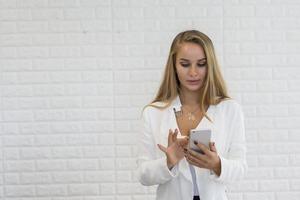 Young business lady using smartphone while working at office photo
