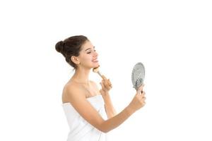 Attractive woman holding and looking at mirror isolated on white background photo