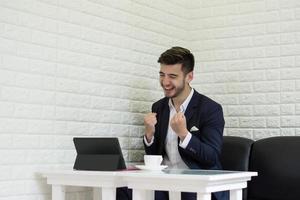 Successful young businessman working on laptop at office photo