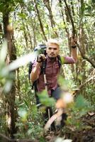 Caminante joven activo aunque el bosque a la montaña foto