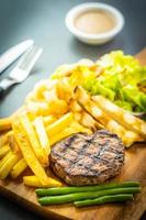 Grilled beef steak with french fries, sauce and fresh vegetables photo