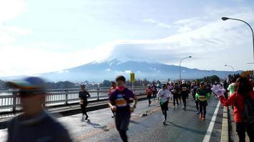 timelapse folla persone che corrono maratona con sfondo di montagna fuji video