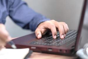 Close up of man hand typing on laptop photo