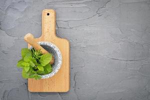 Herbs in a mortar on a cutting board photo