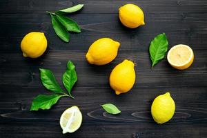 Top view of lemons on a dark wooden background photo