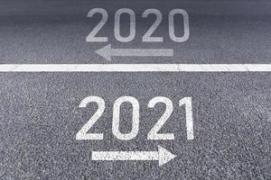 The number 2020 and 2021 written on the road photo