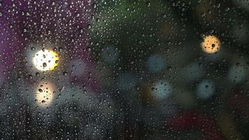 gotas de lluvia en una ventana con luz bokeh video