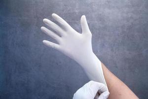 Hand putting on a latex glove photo