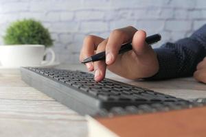Cerca de la mano del hombre escribiendo en el teclado foto