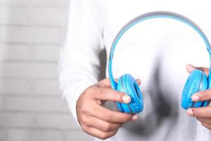 Man holding blue headphones photo