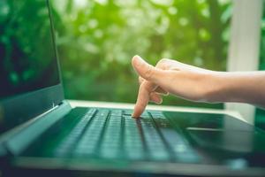 mano de mujer usando una computadora portátil para hacer negocios foto