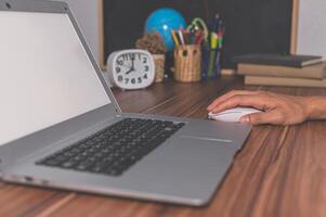 A person using a mouse on a laptop photo